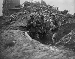 b&W photo of two men in front of a pile of rubble