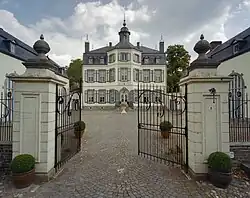 Overzicht van de voorgevel met voorplein, toegangshek met pijlers op de voorgrond - Obbicht - 20408579 - RCE