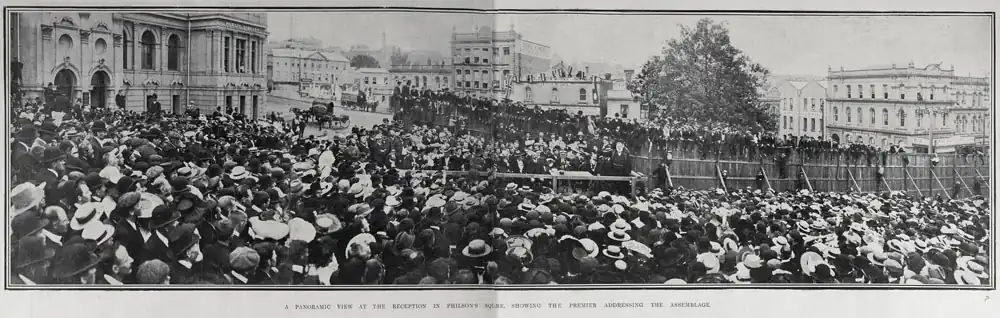 Panoramic view of a large crowd assembled in front of group of speakers
