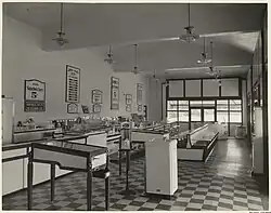 Black and white image of a gleaming chrome and tile ice-cream parlor with large glass windows looking onto the street