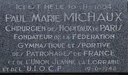 Commemorative plaque on the house where Paul Michaux was born with inscription: "Here was born the 16-11-1854 Paul Marie Michaux, Surgeon of Paris Hospitals Founder of Gymnastics and Sports Federation of France and Sponsorships Union Jeanne Lorraine and UIOCP 19-6-1948."[c]
