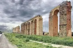 A photograph of a ruined Roman aqueduct