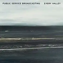 A mostly charcoal grey, lightly blue painting of coal mountains backdropped against a overcast sky. The words "Public Service Broadcasting" and "Every Valley" are written in bold black font on the top left and top right corners of the image, respectively. It is titled "Viaduct', and was painted by Hannah Benkwitz.