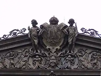 Pura Mangkunagaran coat of arms flanked by European style cherubs and a Dhwarapala