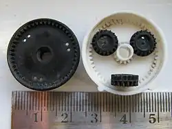 Split ring, compound planet, epicyclic gears of a car rear-view mirror positioner. This has a ratio from input sun gear to output black ring gear of −5/352.