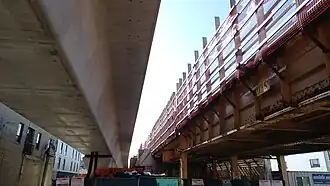 Red and Purple Modernization construction at Lawrence Avenue, showing older embankment and newer box-girder tracks side-by-side