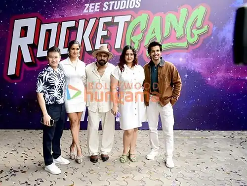 Five smiling young people, standing