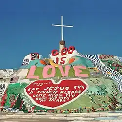 Large painted mountain with "GOD IS LOVE" message prominently displayed