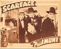 Tony holds a covered Tommy gun with other characters around him in a promotional card for the film stating "Scarface" with Paul Muni
