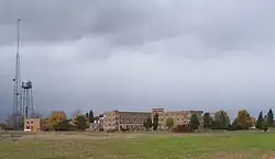 A group of 3-story brick buildings with a water tower and an electrical mast