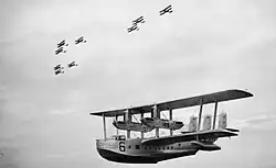 Short Singapore Mk III flying boat of 205 Sqn, in flight below three 'vic' formations of Vickers Vildebeest torpedo bombers of 100 Sqn
