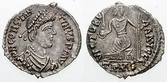 Both sides of a silver coin. One side showing a man's profile, the other a stylised figure bearing a spear and a globe.
