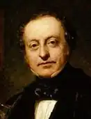 Head and shoulders painting of Sir Charles Barry. Barry is wearing a black jacket, white shirt with high collar and a soft black stock and is looking directly at the painter.