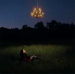 The album cover depicts lead singer of Pale Waves, Heather Baron-Gracie, wearing dark clothing and lying on her back in a grassy field at night. She is looking up at a glowing chandelier mysteriously suspended above her head.
