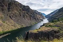 View of a river canyon surrounded by high, broken cliff faces