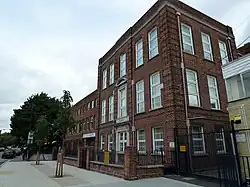 three-storey brick building with sandstone doorways, with a modern annex on the left