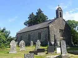 stone church with single belcote and graveyard in foreground