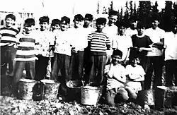 Photograph of male students from Fort Albany Residential School outside with pails c 1945. From the Edmund Metatawabin collection at the University of Algoma.