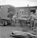 Royal Army Medical Corps, wearing protective clothing, evacuating an inmate suffering from typhus from Bergen-Belsen concentration camp No 1. By 2 May 1945, 6,500 of the sick had been evacuated to hospital.