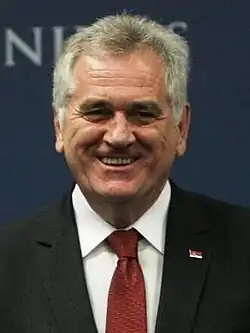 Tomislav Nikolić smiling while Ivica Dačić and Catherine Ashton are shaking hands