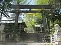 Torii gate of Suwa Taisha Shrine (signboard on the left, memorial tower on the right after climbing up)