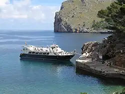 Tourist boat loading passengers at a small quay, Sa Calobra, Mallorca, Spain
