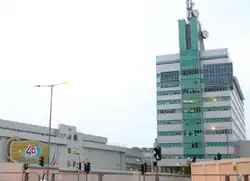 Modern, green-and-white building with dish antennas on top