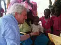 Stephen O'Brien meets a mother and her baby receiving medical treatment at a health centre in Jamam, South Sudan