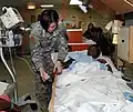 PFC Muenzer checks on a Haitian girl following surgery, Haiti (2010)