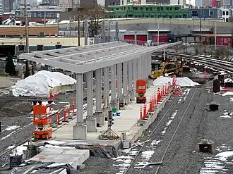 A railway station platform with the frame of a metal canopy