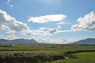 A view of the pass from afar. There are two mountains visible in the distance and there is a flat area between them