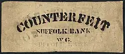 A rectangular piece of paper. Counterfeit is printed on the top. "Suffolk Bank" is in the middle, above "WG"
