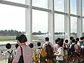 The viewing gallery of Singapore Youth Flying Club overlooking the runway of Seletar. Note the club's Piper Warrior taxiing on the runway.