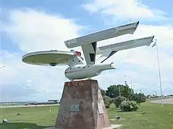 A roadside replica starship atop a stone base