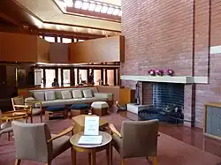 Wingspread's living room, which has a curved brick chimney and built-in furniture