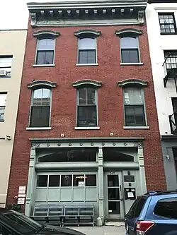 Three-story brick with three windows on each upper floor