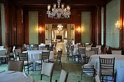 A banquet room with wood and green-paneled walls