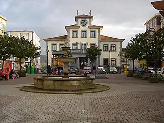A small town square of Narón which features a fountain in the center and buildings on three sides.