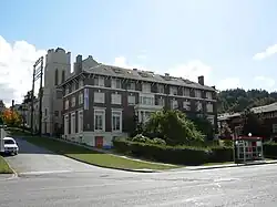 The clubhouse in front of a church with a prominent bell tower